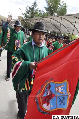 Pobladores de Choque Marka, como homenaje al 10 de Febrero, llevaron una bandera carmesí