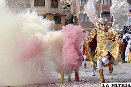 El ángel de la Diablada Auténtica aparece entre el humo con ágil paso