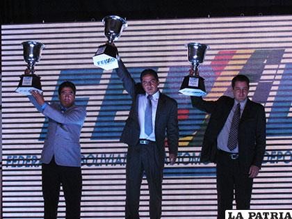 Miguel Flores (centro) con el trofeo de campeón