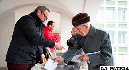 Un adulto mayor vota en una oficina electoral en Appenzell, Suiza