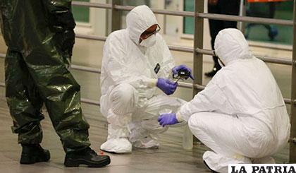 Dos técnicos analizan una muestra en el aeropuerto de Kuala Lumpur, donde fue envenenado Kim Jong-un
