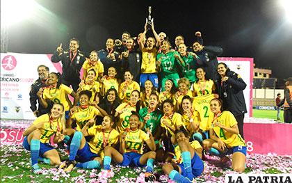 Festejan las integrantes de la selección brasileña con el trofeo en alto /conmebol.com