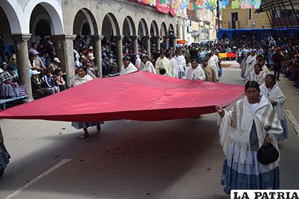 Mujeres comerciantes portan una bandera gigante 