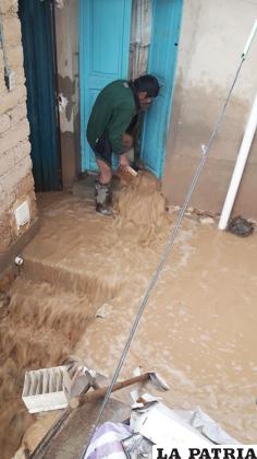 Un vecino saca el agua que inundó toda su casa