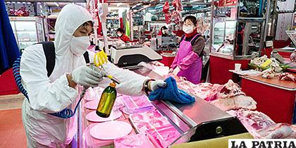 Un trabajador rocía desinfectante como precaución contra el coronavirus (COVID-19) en un mercado tradicional en Seúl, Corea del Sur /EFE