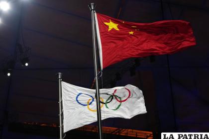 Las banderas de China y olímpica ondean durante la ceremonia de apertura de los Juegos Olímpicos de invierno / AP Foto /Natacha Pisarenko
