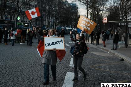 Manifestantes muestran carteles con los lemas “Libertad” (izquierda) y “Caravana de la libertad” (derecha) 
/AP Foto/Thibault Camus