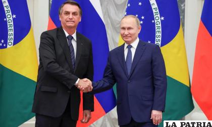 El presidente ruso Vladimir Putin, derecha, y el de Brasil, Jair Bolsonaro se estrechan las manos tras una conferencia de prensa /Mikhail Klimentyev, Sputnik, Kremlin Pool Foto vía AP