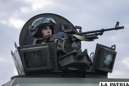 Un soldado de la Guardia Nacional ucraniana custodia un puesto de control móvil junto a agentes de los servicios de seguridad y policías /AP Foto /Evgeniy Maloletka
