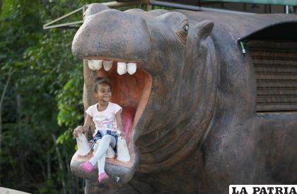 Una niña posa para una foto en una estatua de un hipopótamo en la entrada de Hacienda Nápoles /AP Foto /Fernando Vergara