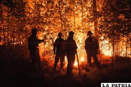 Bomberos trabajando en el lugar de un incendio cerca del poblado de Kyuyorelyakh, Rusia
/AP Foto /Ivan Nikiforov, Archivo