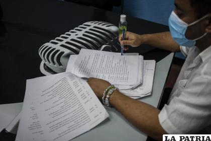 Enrique Ínsula, director de la radionovela “La lluvia eres tú”, revisa el guion en el estudio de grabación /AP Foto/Ramón Espinosa