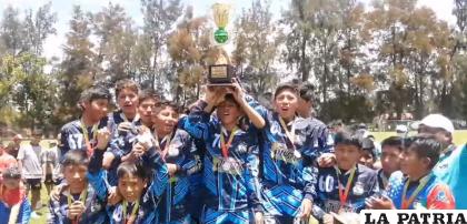 Integrantes de Futuro FC subcampeones de la división Sub-14 celebran con el trofeo en alto /RR.SS.
