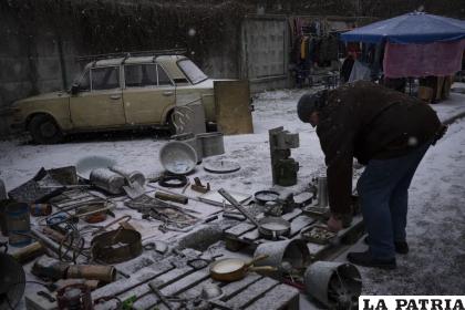 Un hombre ve objetos en un mercado de pulgas en Kiev /AP Foto/Daniel Cole