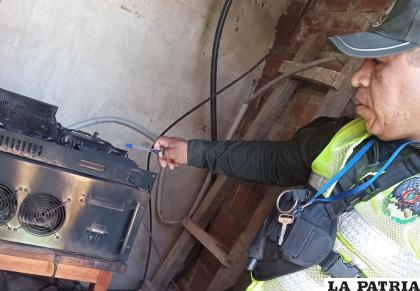 Un policía observa uno de los equipos de transmisión radial incendiados /Radio Melodía Yungueña

