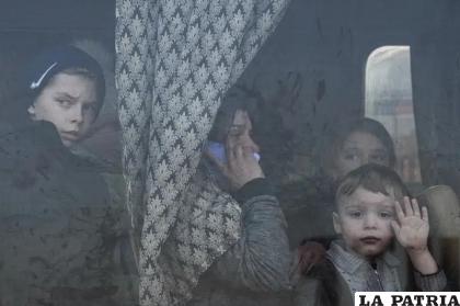 Personas desplazadas miran desde un bus en un centro para refugiados en Zaporiyia, Ucrania /AP Foto/Evgeniy Maloletka, File