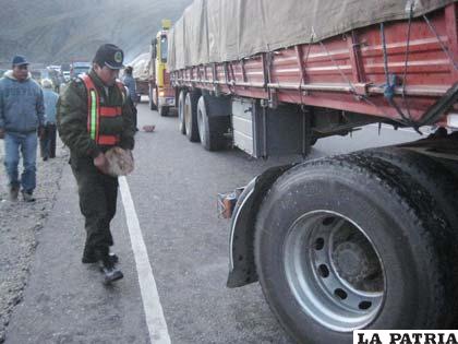 El Sgto. Rogelio Condori lleva una piedra para evitar que el camión se deslice