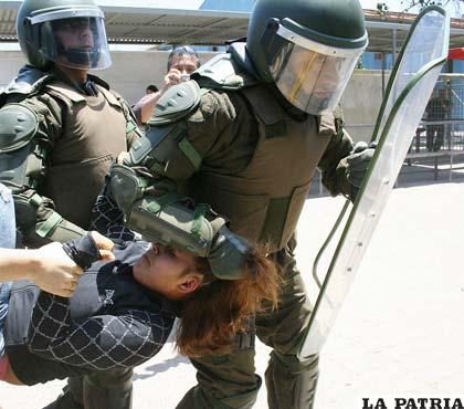 Policías llevando a una estudiante que pide mejoras a nivel de educación en Chile