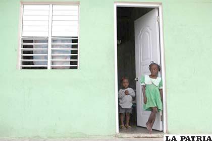 Dos niños ven la calle desde su casa del Batey Paraíso II en República Dominicana
