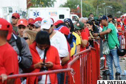 Miles de personas se aglutinan frente a la Academia Militar de Caracas para ver el cuerpo del fallecido líder venezolano, Hugo Chávez