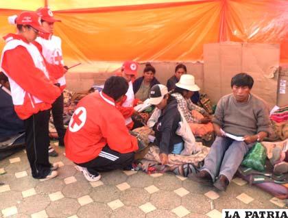 Voluntarios de la Cruz Roja, revisan a los huelquistas