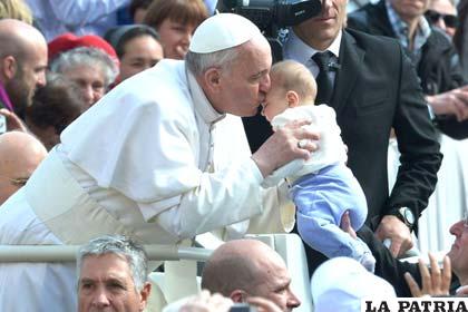 El Papa Francisco besa en señal de bendición la cabeza de un infante