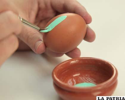 PASO 1
Para colorear huevos de Pascua, lo primero que debes hacer es tomar un huevo y cubrirlo completamente con uno de los colores de pintura. Usa el pincel para colocar la pintura en el huevo poco a poco hasta que acabes por cubrirlo por completo.