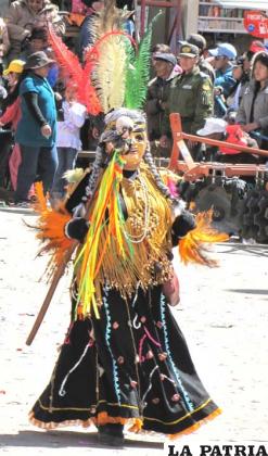 ABUELA: Este personaje representa el saber y conocimiento adquirido por las mujeres a lo largo de su vida, en la danza es la compañera del brujo.
Tiene en su cabeza un adorno de plumas de colores que se arma en la parte de atrás sujetada con un cintillo tejido con lanas de color, lleva una peluca gris recogida en dos trenzas que caen a ambos lados de los hombros.
La máscara está elaborada de material sintético con rasgos de una mujer anciana con arrugas, lleva una túnica o vestido de manga larga con falda ancha que llega hasta los tobillos, hecha de bayeta, adornada con espejos y plumas multicolores, dispuestos en la parte baja de toda la túnica.
Tiene un ponchillo hecho con hilo sintético, tejido de macramé intercalado con cuentas de madera y sintéticas a la altura del pecho cuelgan una serie de flecos largos hasta la cintura, también lleva caretas pequeñas hechas de macramé.
Usa guantes de lana, puñera hecha de aguayo con plumas, en la cintura lleva faja ancha elaborada con tela de aguayo con monedas en la parte delantera y zapatillas forradas con tela del mismo color del traje.