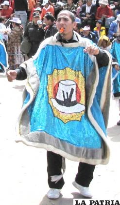 KUNTURI (CÓNDOR): El cóndor es considerado como una deidad andina, protector de los dones de la Pachamama y de la gente del altiplano. En la cosmovisión andina, esta persona representa al taypi (medio) o nexo entre el bien y el mal, el cual roba a las ovejas del rebaño.
Lleva un blusón de algodón. El poncho por lo general está hecho de lana de oveja, sin embargo, en la actualidad se utilizan materiales sintéticos con detalles de acuerdo a las características del conjunto folklórico. El largo es casi hasta el tobillo y el ancho hasta las muñecas. En el cuello tiene una especie de plumón que representa el cuello y las alas del cóndor en actitud de vuelo.
No lleva nada en las manos, en la cintura tiene una faja o chumpi, el vestuario se complementa con un pantalón y zapatillas.