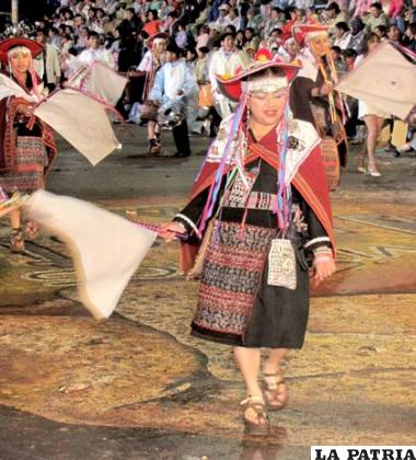 ÑUSTA: Este personaje representa la pureza de la mujer joven dentro de la comunidad, preparada para ser elegida para el matrimonio, ataviada con riquísima vestimenta tejida y ondeantes banderas o whipalas blancas.
Su cabeza está cubierta por la pacha montera, que tiene la forma de pagoda china, hecha de fieltro elegantemente bordado; en su frente luce una vincha o w’itiña, que es adornada con mostacillas, lentejuelas e illas (monedas antiguas).
En la parte superior de su cuerpo lleva la almilla, que es un tipo de blusa de color negro elaborado de tocuyo; la llijlla o aguayo amplio que se caracteriza por llevar el color guindo y rojo que está sobre su espalda; además de los tupus de plata.
La whipala o banderilla es blanca hecha de bayetilla de un tamaño aproximado de 80 x 80 centímetros, que es ondeada constantemente durante su baile.
En la cintura ostentan un ajsu o tejido genuino yampara, que se acompaña con la faja o cañarí que también lleva motivos de esta cultura y por supuesto las phatu ujutas, elaboradas con una madera bastante resistente.