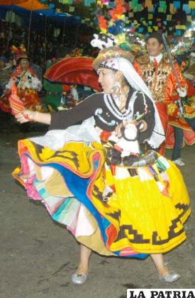 MAMA TH’ALLA: Es la compañera del jilakata, juntos son autoridades originarias del ayllu, es la encargada de velar por el interés de los comunarios.
Este personaje lleva un sombrero hecho con lana de oveja, adornado con lentejuelas y cintas de colores, el cabello recogido en trenzas sujetadas con tullmas, lleva un rebozo que cubre la cabeza y llega hasta el borde de la pollera, confeccionada de tela brillosa (semejante a las lentejuelas) y en el borde lleva tela de aguayo.
Además tiene la blusa cosida en base a bayeta de la tierra, adornada en el pecho con zigzag con los colores de la tricolor boliviana (rojo, amarillo y verde), lentejuelas y canutillos bordados.
Lleva también tupus o alfileres utilizados para sujetar el reboso, está hecho de oro o plata, cuyas cabezas muy particulares y grandes presentan una plancha delgada y redonda trabajada en alto relieve.
Tiene una inkuña o tarilla, pañuelo hecho de aguayo, anudado en una de sus puntas en el que se lleva coca.
Suele llevar una jarra o lechera hecha de hojalata trabajada en alto relieve, adornada con borlas de colores.
La danzarina lleva la pollera principal amplia y larga, hasta la rodilla, elaborada con bayeta de la tierra de color amarillo con tres alforzas, como adorno lleva líneas negras que forman figuras geométricas en la parte baja de la pollera, además tiene enaguas (cuatro) elaboradas de bayeta de la tierra de colores vivos, van debajo de la pollera para dar volumen al traje.