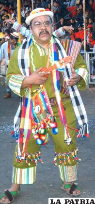 DANZARÍN VARÓN: Representa al comunario que muestra su esfuerzo en el trabajo y sus habilidades al momento de conquistar a una mujer, lleva en la mano un charango pequeño que es su fiel compañero y le sirve para interpretar alguna melodía al momento de enamorar a la imilla.
Lleva un sombrero de ala angosta adornado con diferentes colores. En la parte posterior tiene una trenza colgada y agarrada con tullmas.
El blusón que utiliza tiene mangas largas y anchas, la forma del cuello es tipo cadete con una pequeña abertura, los bordes están adornados con cintas y bordados con ribetes de colores.
Lleva una chalina multicolor que se extiende hasta las rodillas, también una manta decorada con colores brillantes y flecaduras, que va en el hombro izquierdo.
Igualmente lleva el aguayo doblado de forma triangular y amarrado en la cintura.
Usa un pantalón hecho de bayeta de la tierra que llega hasta las canillas, en los bordes tiene bordados que hacen referencia a la actividad agraria, el danzarín varón lleva sandalias de cuero, en muchos casos pintadas del color del traje.