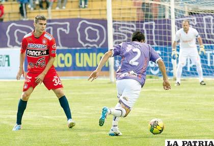 Miguel Hurtado escapa con balón dominado ante la mirada de Ezequiel Filipetto