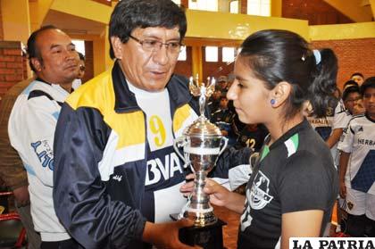 El presidente de la asociación, Zenón Vela, entrega el trofeo del campeonato, a Tatiana Tito, de Santa Rosa