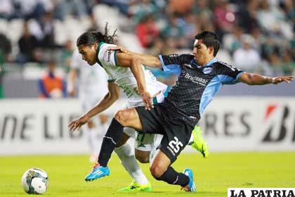 Damir Miranda, jugador de Bolívar, intenta evitar que su rival domine la pelota
