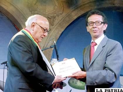 El escritor-periodista cultural orureño, Mario Ríos Gastelú (izq.) recibe el premio del ministro Pablo Groux (der.)