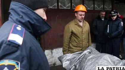 Miembros de los grupos de rescate sacan a los muertos de la mina