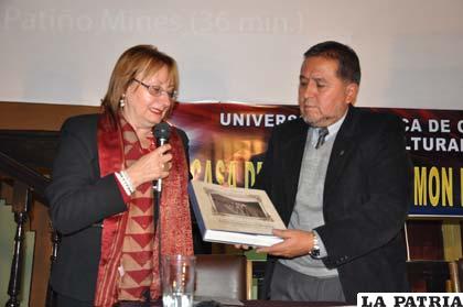 La directora del Espacio “Simón I. Patiño”, Michela Pentimelli, entrega la producción bibliográfica al rector de la UTO Carlos Antezana