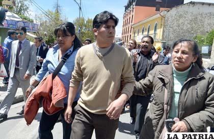 Carlos Quisbert tras recibir su libertad custodiado por sus compañeros de trabajo
