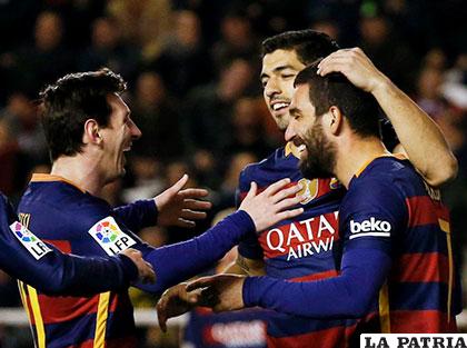Messi que hizo triplete, celebra con Suárez y Arda