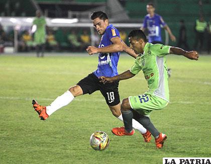 Guery García intenta rematar ante la marca de Leonardo Vaca
