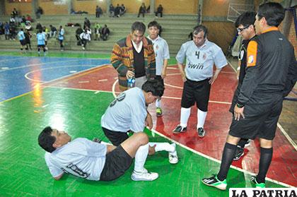 El jugador Eduardo Buendía en el piso con la lesión en el tobillo