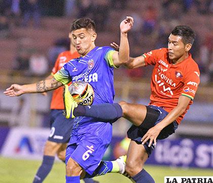 Víctor Hugo Melgar disputa el balón con Rudy Cardozo