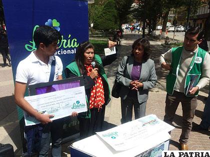 Cristian Arias al momento de recibir su cheque con el segundo premio de la lotería /Archivo