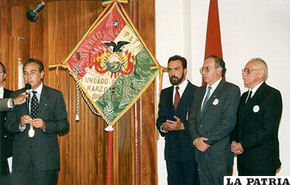 El ex presidente del Senado, Guillermo Fortún, condecora el estandarte de LA PATRIA ante la vista de Marcelo y Enrique Miralles, por su labor a favor del periodismo