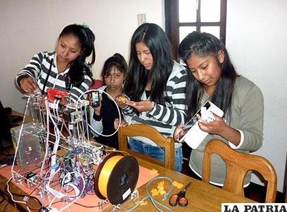 Mujeres adolescentes de secundaria trabajan en el armado de sus robots
