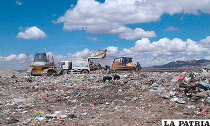 El trabajo de compactado de basura con maquinaria en el relleno sanitario /EMAO