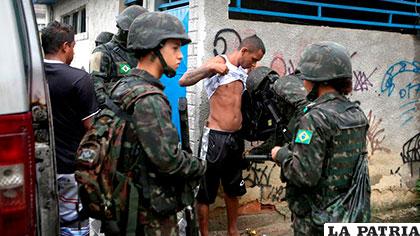 Fuerzas armadas registran a un joven en la favela de Vila Kennedy, en Rio de Janeiro /lavanguardia.com