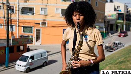 Crisbel López toca su saxofón, en el barrio Sabana perdida de Santo Domingo