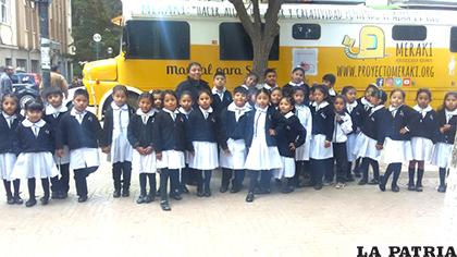 Los niños de la U.E. Juana Azurduy de Padilla junto al bus del proyecto Meraki /LA PATRIA